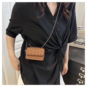 Detail view of brown quilted mini crossbody bag with golden chain strap and flip cover