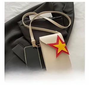 Détail de la pochette bandoulière en cuir crème avec motif patchwork d'étoiles colorées
