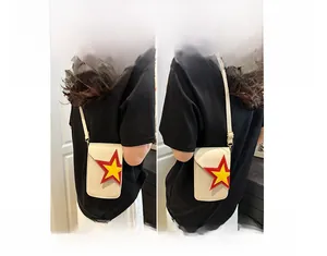 Vue détaillée du mini sac bandoulière crème avec étoile jaune montrant le porté épaule et croisé
