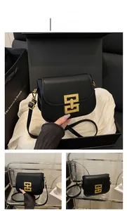 Detail view of black vintage shoulder bag featuring a striking gold geometric clasp lock