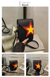 Détail d'un petit sac bandoulière noir avec motif étoile superposé rouge et jaune élégant