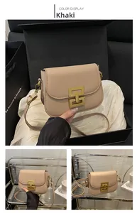 Detail view of khaki retro crossbody bag with a metallic square buckle on glossy leather