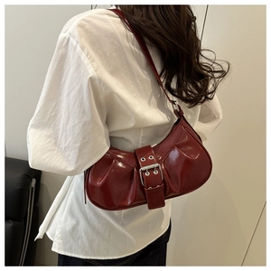Detail of vintage burgundy pleated crescent bag with large silver metal buckle strap