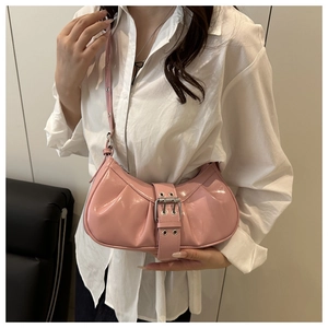 Detailed view of pink patent leather moon bag with pleated texture and silver buckle