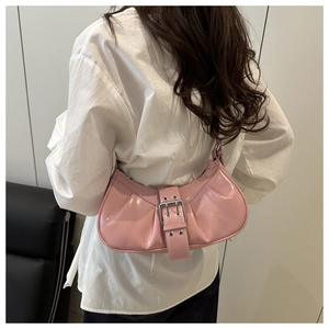 Pink crescent underarm bag featuring glossy pleated leather and a metallic belt buckle detail
