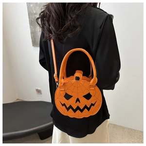 Detail shot of a pumpkin shaped handbag for Halloween featuring spider web patterns