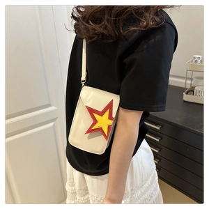 Détail d'un mini sac crème bandoulière avec un motif d'étoile superposé rouge et jaune