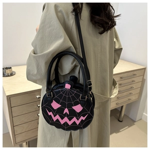 Black pumpkin-shaped crossbody bag with pink spider web embroidery shown on model