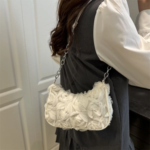 Romantische weiße Netztasche mit Blumen und Kette, auf der Schulter des Models
