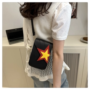 Détail d'un sac bandoulière noir en cuir avec surpiqûres doubles étoiles colorées sur le rabat