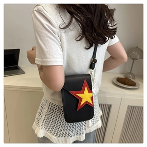 Détail d'un mini sac bandoulière noir avec un motif d'étoile rouge et jaune vif