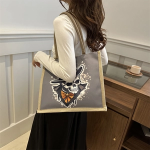 Halloween skull canvas tote bag with gray body and woven trim shown on model