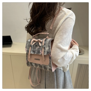 Detail of pink bow, heart pendant, and butterfly print on stylish small casual backpack