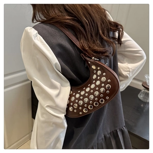 Model view of a brown crescent shoulder bag with vintage silver rivets for casual wear