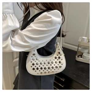 Close-up of white crescent bag with silver rivets and smooth leather texture