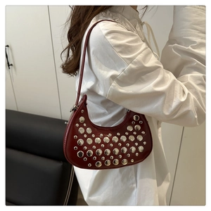 Detail of burgundy crescent bag with silver studs and Y2K retro shiny patent leather