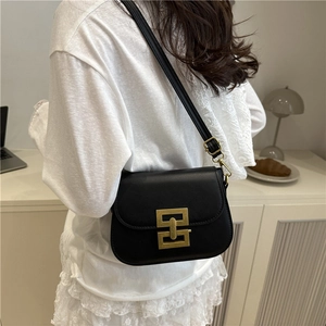 Chic black faux leather saddle bag with gold buckle and adjustable chain strap
