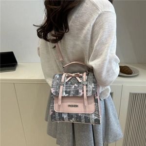 Fashionable pink and grey butterfly print backpack with bow detail worn by a model