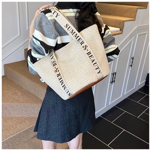 Détail du sac seau tressé avec bandoulière Summer & Beauty porté à l'épaule