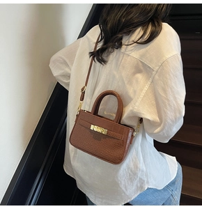 Detail of brown crocodile pattern mini crossbody bag with gold metallic twist lock
