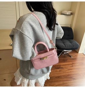 Pink stone pattern handbag detail with gold metal lock on premium textured leather