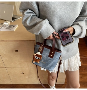 Sac à bandoulière en denim avec breloque monstre présenté par un mannequin chez soi