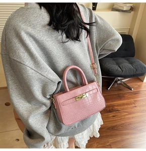 Pink stone texture handbag shown with adjustable strap in a stylish lifestyle setting
