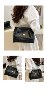 Detail of black crossbody bag with snake print texture and golden chain strap