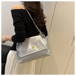 Detail of silver tote bag with snake skin texture, gold metal buckle and chain strap