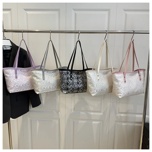 Detail showing five colors of plaid tote bags with geometric patterns on a metal rack