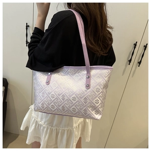 Detail of lavender tote bag featuring embossed jacquard pattern and slim shoulder strap