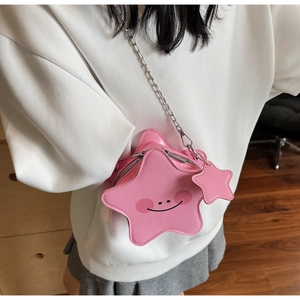 Detailed view of pink star-shaped bag with cartoon smile and silver chain strap