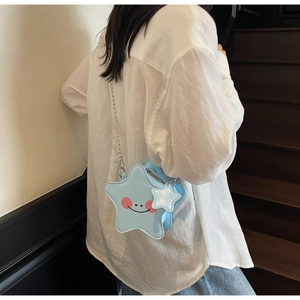 Detail of light blue star-shaped crossbody bag with minimalist smile and chain strap