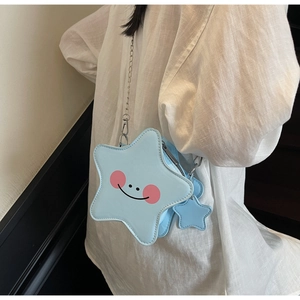 Detailed shot of light blue star-shaped crossbody bag with cartoon face and chain strap