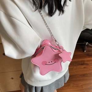 Pink star-shaped crossbody bag with a smiley face and metal chain strap on a model