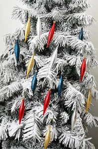 Detailansicht der spiralig strukturierten Weihnachtsanhänger an einem verschneiten Ast