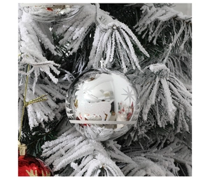 Bola de Navidad plateada con ciervos y copos de nieve colgada en árbol nevado