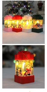 Close-up of four colored Christmas lantern gift boxes with warm LED lights and festive bows