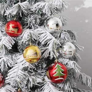 Bolas de Navidad de 10cm con motivos de renos colgadas en un árbol de Navidad nevado