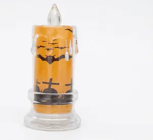 Dettaglio di candela LED arancione con motivi neri di pipistrelli e croci per Halloween