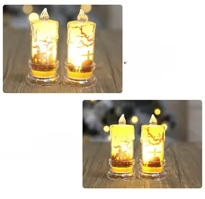 Dettaglio di due candele LED di Halloween con sagome di castelli e pipistrelli su legno