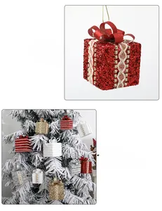 Detailed view of lace-trimmed glitter gift box ornaments hanging on a Christmas tree