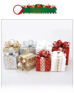 Close-up of glittery Christmas gift box ornaments with lace ribbons in four festive colors