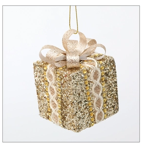 Macro detail of golden Christmas tree gift box ornament with glitter and bow decor