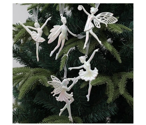 Detail of five pearlescent white ballerina fairy ornaments hanging on a Christmas tree branch