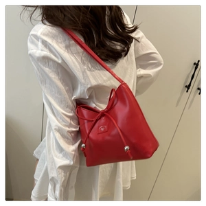 Dettaglio della borsa a secchiello rossa con chiusura a coulisse e logo con fiocco