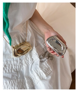 Detail of mini metallic oval bags in gold and silver finish with fine chain straps