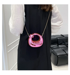 Detail of rose pink mirror acrylic mini round bag with elegant gold chain strap