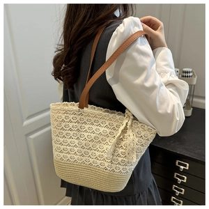 Détail d'un sac cabas en dentelle tressée avec bandoulières en cuir marron