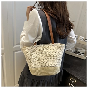 Détail du sac à bandoulière en dentelle et paille avec élégante sangle en cuir marron